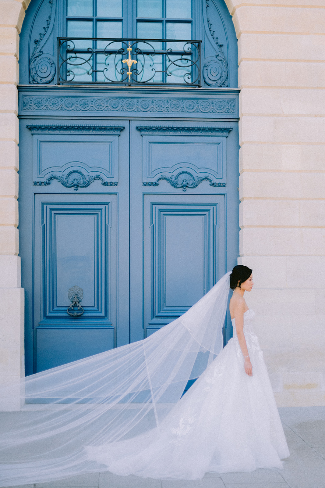 Bride posing in front of a blue door at Place Vendôme in Paris